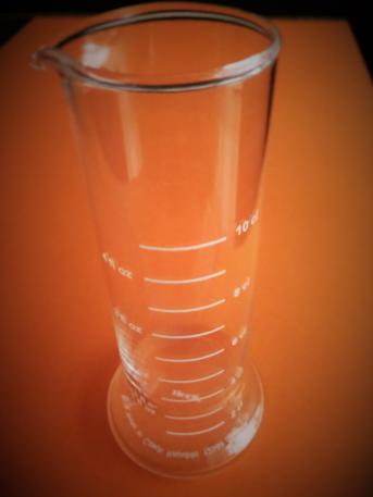 Imagen de un recipiente con escala de volumen expresada en diversas unidades.