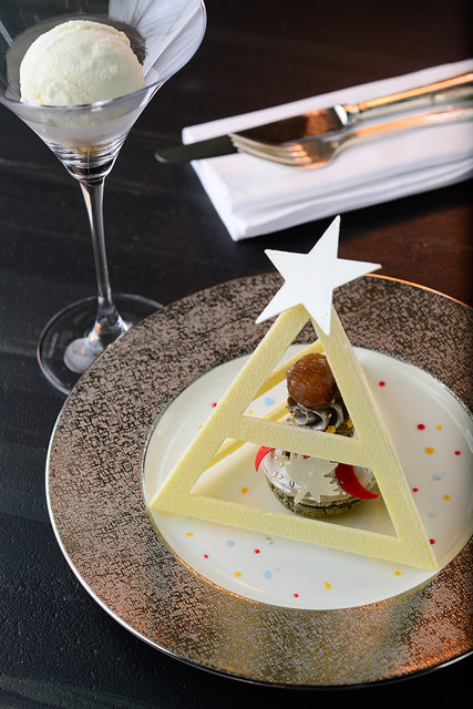 Imagen de un postere con una estructura de chocolate con forma pirámide triangular.