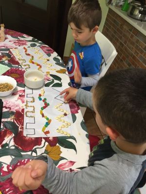 Óliver e Moisés traballando a psicomotricidade fina con chuches.
