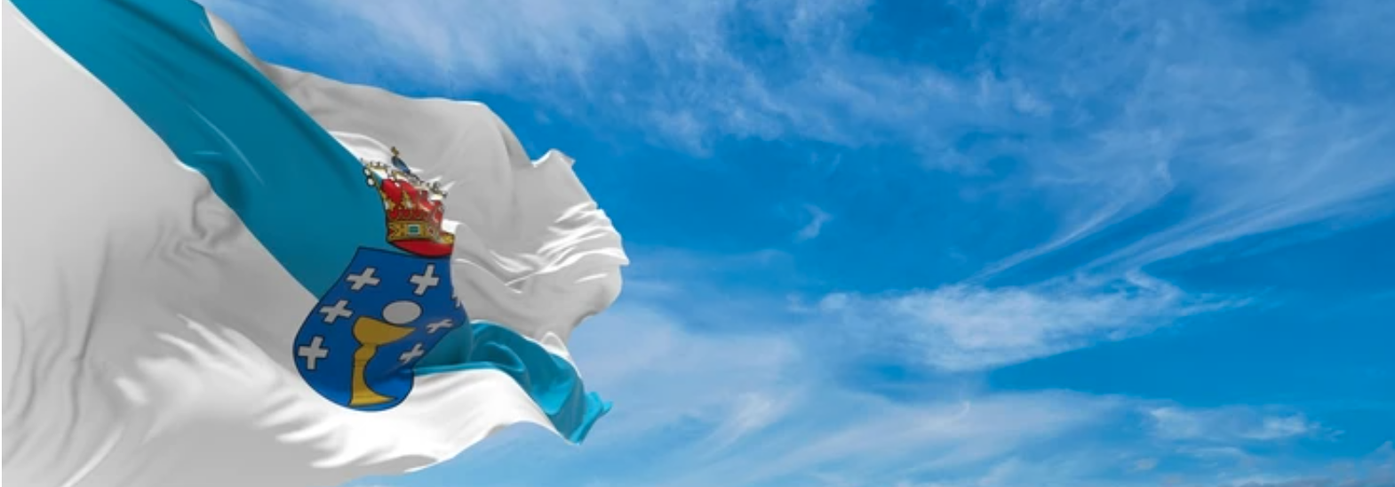 Bandera de Galicia ondeando y de fondo un cielo azul con algo de nubes. 
