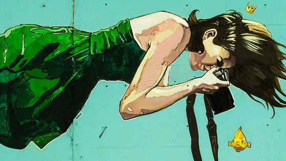 Graffiti de una mujer bajo el mar con una cámara de fotos