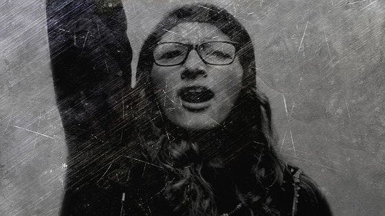 Una mujer con el brazo en alto en gesto de reivindicación