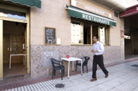 Hugo caminando a punto de entrar en la panadería.