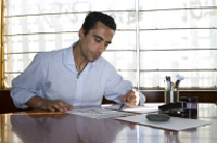 Ramón revisa el control de ventas en su mesa de trabajo.