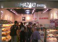 Grupo grande de clientes en una panadería.