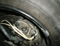 Ubicación en la parte interior de la rueda del sensor de desgaste de pastillas de freno con dos cables.