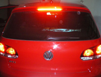 Vista trasera de vehículo con luces de freno activadas.