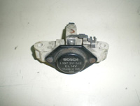 Regulador de tensión de un alternador del tipo Bosch. Tiene forma redondeada y dos escobillas.