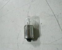 Lámpara incandescente tipo control con casquillo metálico cilíndrico y ampolla de vidrio sobre él.