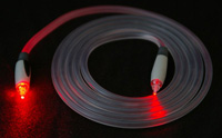 Cable de fibra óptica enrollado con ambos extremos iluminados.