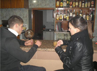 Un muchacho de unos 20 años de pelo negro toma café en la barra de un bar junto a una muchacha de iguakes características 2.