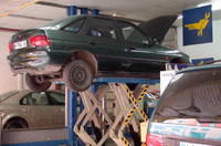 Vehículo en taller sobre elevador.