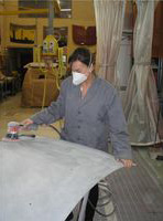 María  lijando un capó.