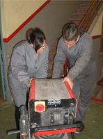 María y Lorenzo mirando los parámetros de una máquina de soldadura.