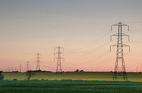 Fotografía de varios postes eléctricos al atardecer.