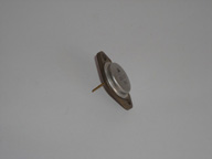 En la imagen tenemos un transistor, formado con un pequeño cilindro como una moneda y pegado sobre una brida para sujetarlo al circuito con unos tornillos.