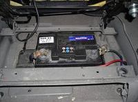 En la imagen se ve una batería en su soporte en el interior de un coche.