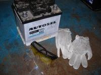 En la imagen se ve una batería dos pares de gafas y un par de guantes de nitrilo.