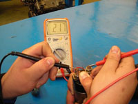 En la fotografía se ve un como se comprueba el la continuidad de los contactos en posición de cerrado del relé de un motor de arranque  mediante un polímetro.