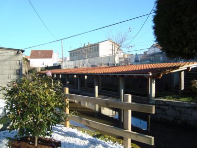 O lavadoiro, ao fondo a Escola
