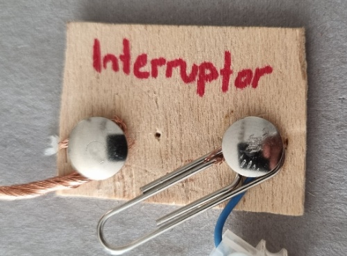 En la imagen puede verse un interruptor fabricado con un clip y dos chinchetas