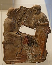 Terre cuite de 480-460 av. J.‑C., provenant d'une tombe de M&eacute;los et conserv&eacute;e au British Museum. On suppose qu'il s'agit de l'une des plus anciennes repr&eacute;sentations de Sappho, ici tenant un barbitos, en conversation avec un homme, peut-&ecirc;tre Alc&eacute;e.