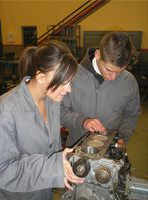 María y Lorenzo revisando el bloque de un motor.