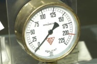 Foto de un manómetro, redondo con la aguja marcando el cero.