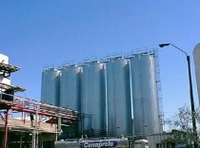 Fotografía de un conjunto de silos isotérmicos para el almacenado de la leche. Son estructuras tubulares muy grandes de color azul con una altura de varios pisos.