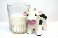 magen de un vaso de leche con una vaca de juguete asociando la leche a la infancia.