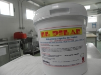 Se aprecia un bote de albúmnia de huevo en una mesa de un obrador de pastelería, con maquinaria en el fondo.