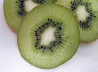 Podemos ver tres  mitades de kiwi, con las semillas.