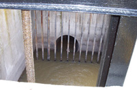 En la imagen se ven aguas residuales pasando a través de una reja.