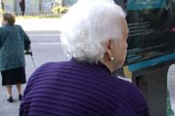  Imagen de una anciana vista de espaldas con el cabello totalmente blanco.  Tiene una rebeca violeta.