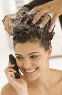  Imagen de una chica que habla por teléfono mientras le lavan el cabello