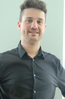  Imagen correspondiente al caso práctico, de un profesional vestido con camisa negra que posa de frente hacia la cámara, sonriendo.