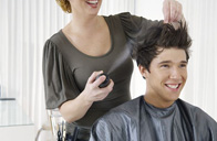 Se observa un cliente atendido por una profesional de la peluquería.