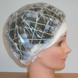 Maniquí de prácticas con los bigudíes puestos y el gorro de plástico.