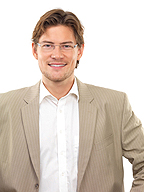 Se puede ver a una persona del sexo masculino, de medio cuerpo, con gafas.