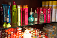 Se ven dos estanterias repletas de productos de peluquería.