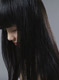 Mujer cabello largo oscuro. Se ve una mujer con el rostro cabizbajo. Tiene el cabello largo y oscuro.