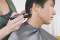 Máquina con recalce. Se ve un usuario al que le cortan el cabello con máquina con recalce.