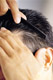 Detalle de lado rapado. Se ve un hombre que peina su cabello, lleva el lateral muy rapado.