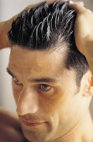 Se ve un hombre aplicando algún cosmético y colocando su cabello hacia atrás.