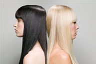 Se ven dos chicas de perfil, ambas llevan el mismo corte de cabello con la misma textura y peinado. La de la izquierda tiene el cabello negro y la de la derecha rubio.